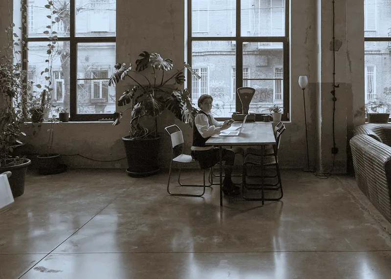 a person sitting at a table with a laptop